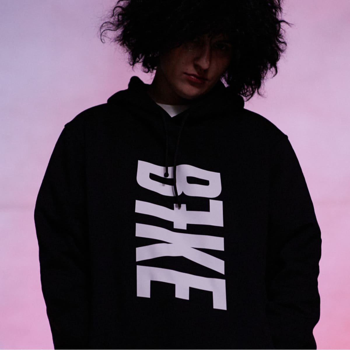 A girl with hoodie which has title B7ke on it. 