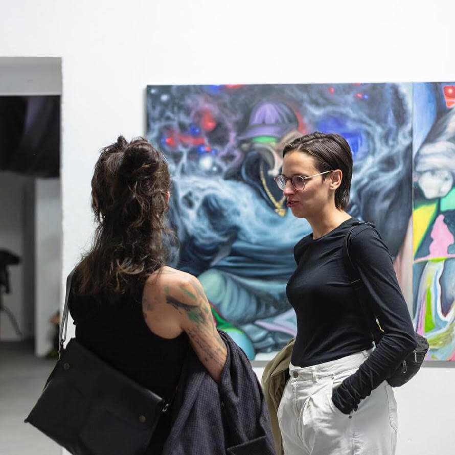Two women chatting in an exhibition.